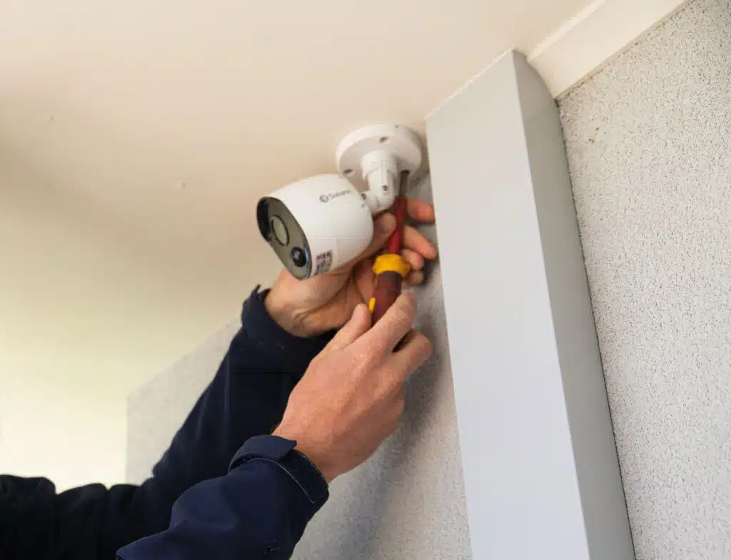 A Gorey Electrical employee installing a security camera into the ceiling