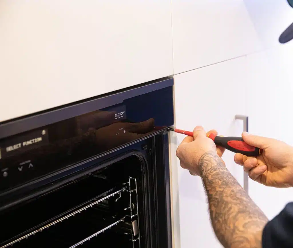 Electrician repairing an electric oven