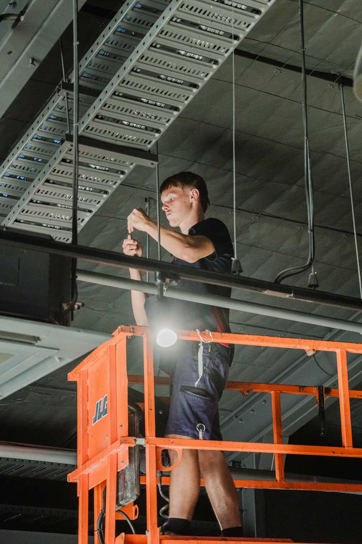 Electrician installing industrial lighting