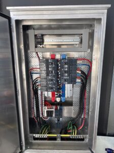 Open electrical switchboard showing neatly installed circuit breakers, busbars and wiring.